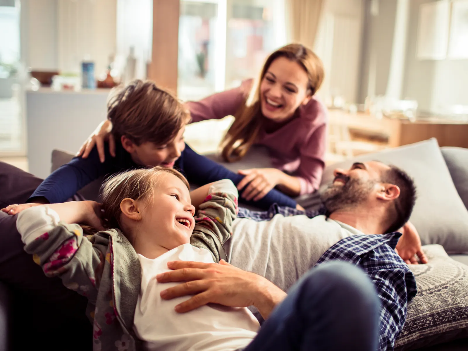 Famiglia cun dus uffants a chasa sin il sofa – taxaziun cuminaivla per pèrs maridads e famiglias